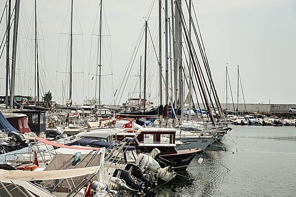 Photo by Crab Lens A busy marina in Istanbul with sailboats and yachts docked under a calm sky.